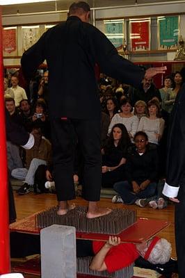 Discipline technique, standing on nail bed in bare feet, bottom lady takes the weight while laying on another nail bed.