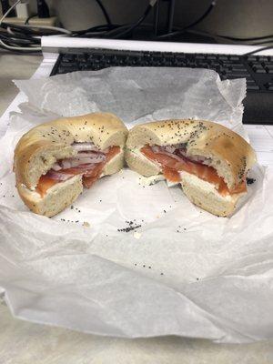 Bagel with cream cheese, lox and purple onion.