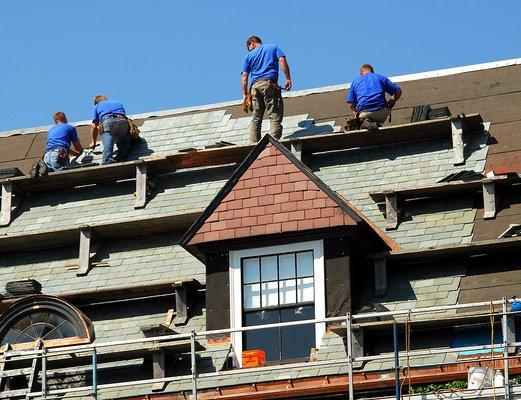 Slate roof being installed on a steep roof with jack and boards. Very difficult and time consuming.