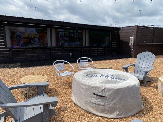 Seating with a firepit near the big screen TVs