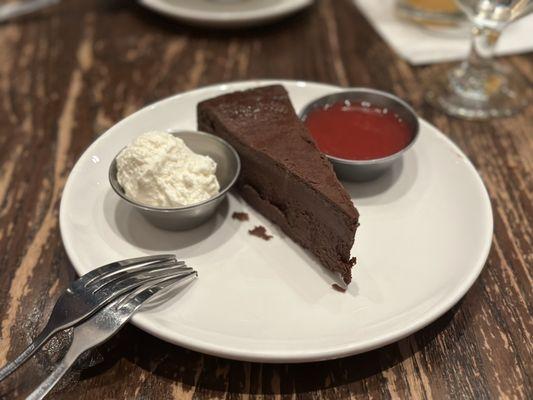 Flourless chocolate cake with whipped cream and strawberry sauce