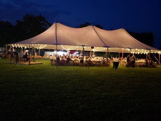 Aurora sheer sailcloth tent with cafe streamer lighting at night