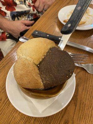 Pot of bread with white, wheat and Bavarian bread served with caramel flavored butter.