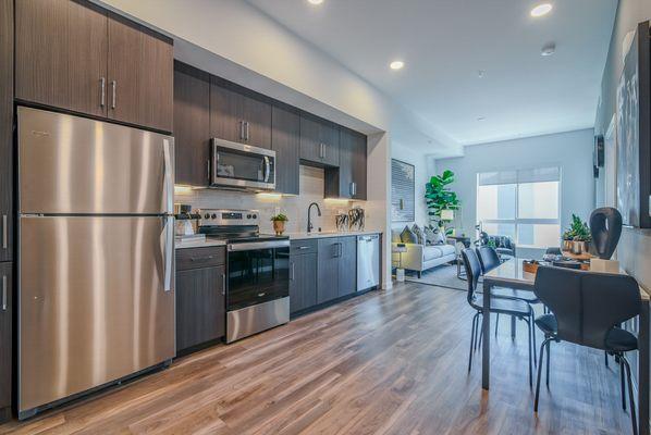 Kitchen with stainless steel appliances, quartz countertops and hard surface flooring.