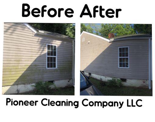 Pressure washing house by removing mildew and grime.