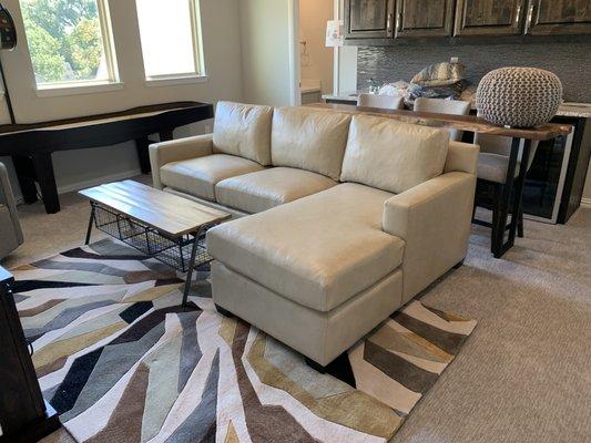 L-shaped sectional also made from scratch. Upholstered in leather with dark walnut stained legs.