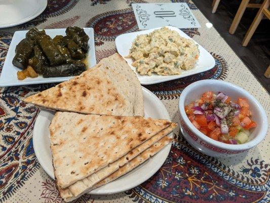 Stuffed grape leaves, olovieh, shirazi salad and pita bread