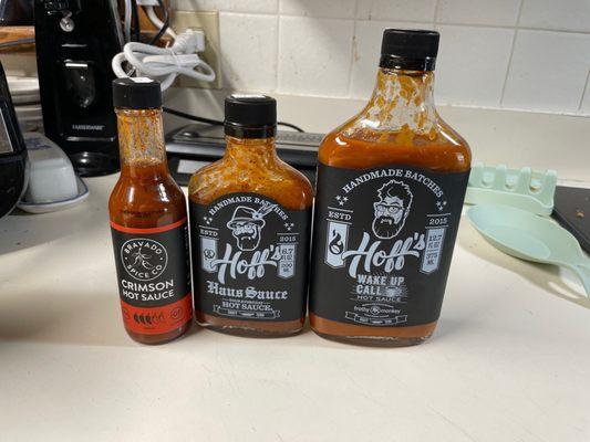 The tall one is hoffs wake up call hot sauce, the middle is hoffs haus sauce and the thin one is crimson hot sauce.