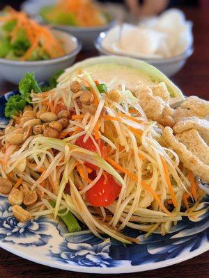 SL3. Papaya Salad. $7. Shredded papaya and carrot, string beans, tomato, peanuts, Thai chili-lime dressing, crispy pork rinds.