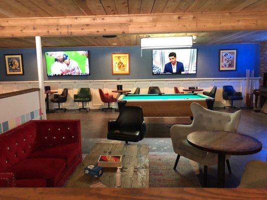 Nice living room like area, pool table, TVs.