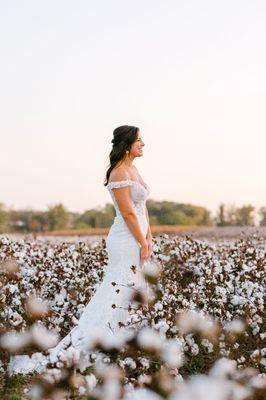 Bride in cotton fields at farm/barn wedding venue.