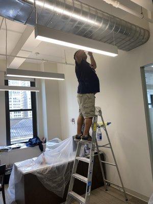 Janitor deep cleaning high ducts in an office building