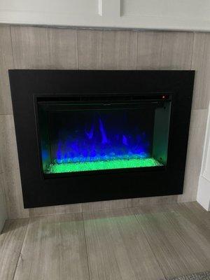 Modern Flames electric fireplace in place of my old unsightly wood burning one, displaying Seattle colors.