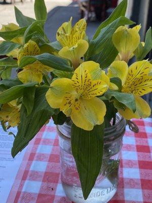 Table in the shade with fresh flowers. Sweet.