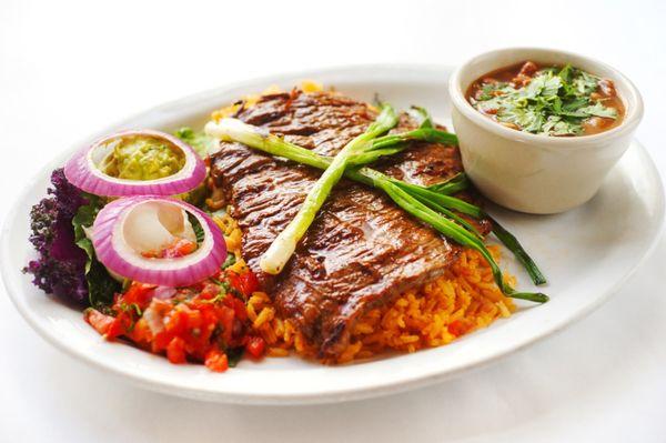 Carne Asada - Marinated, grilled beef served on a bed of rice along w/ fresh guacamole,
 sour cream, pico de gallo, a cup of Mex bean soup