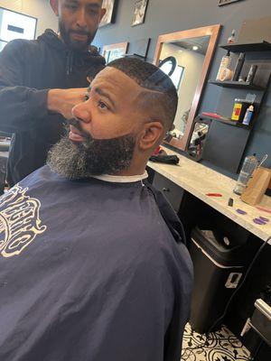 Mid skin fade 
with died beard and trim/ edged with a straight blade