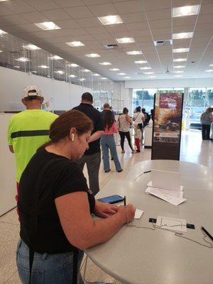 This gal with black t-shirt left her position in line to use teller without asking to reserve her spot. She took cash out of teller.