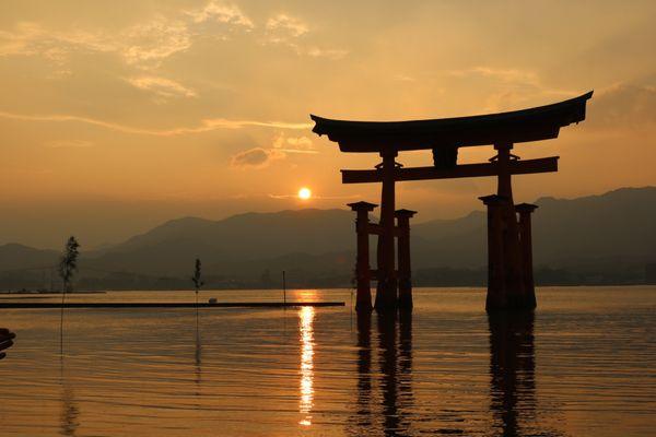 At sunset, Itsukushima Torii Gate seems to float on water at high tide on Miyajima Island, Hiroshima, Japan.