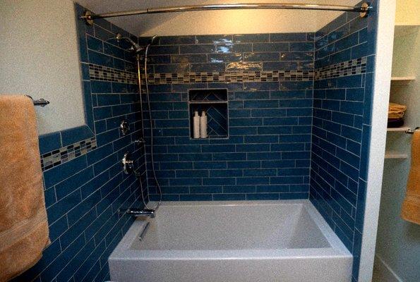 New soaker tub with inset and handheld shower.  Note the linen shelves.