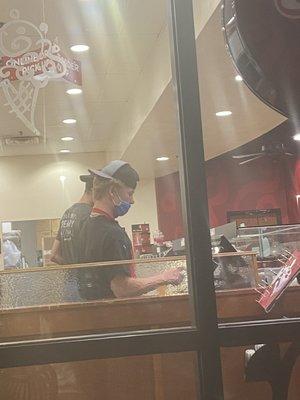 Worker wearing his mask below the nose while taking a customers order.