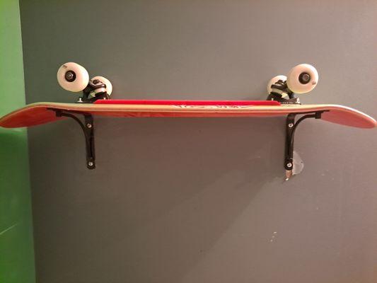 Skateboard in place of a shelf in the bathroom. Very cool.