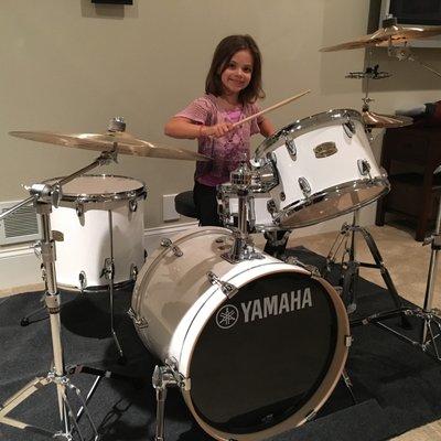 A bright young student excited about her new Yamaha Stage Custom drum kit.