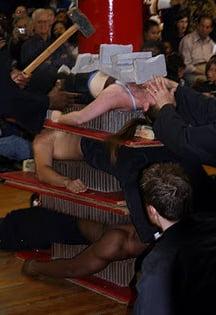 Discipline technique, nail bed pile with concrete blocks being broken on top person.