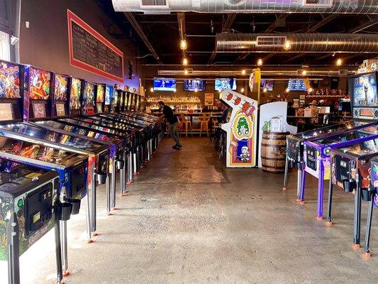 View after stepping inside, pinball machines on both sides, bar on far end, tons more games and seating to the right