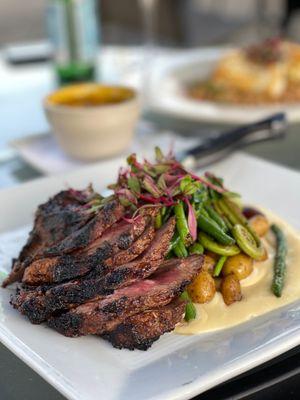 Hanger steak with fiddleheads, green beans, fingerling potatoes, on a cauliflower cheese purée