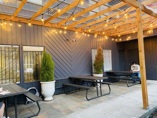 Covered outdoor dining area is in an alcove sheltered from the wind