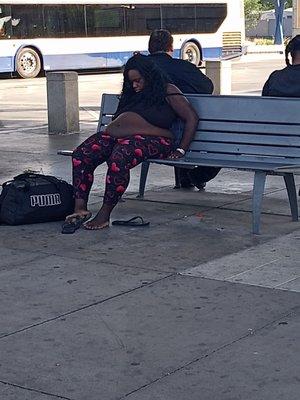 Homeless with dirty feet sleeping at the bus station.