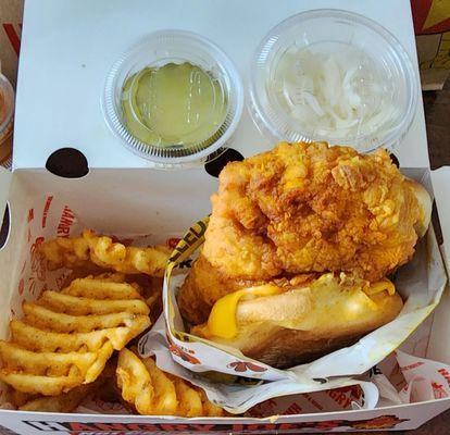 Spicy Chicken sandwich with waffle fries with side of pickles and slaw. Spice level Hot