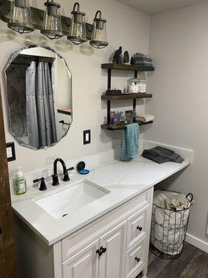 Bathroom remodel with new drywall, vanity, marble counter tops, shelving, electrical, mirror and fixtures.