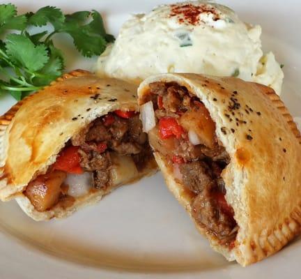 Lomo saltado empanada, beef, potatoes, sundry tomatos and onions.