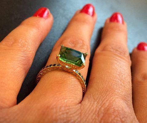 Yellow gold with a sideways prong-set 2.32 ct cushion mint green tourmaline. Black diamonds. Hand engraved sides.