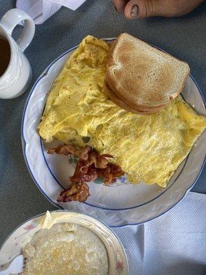 Meat lover's omelette, toast, bacon, and grits