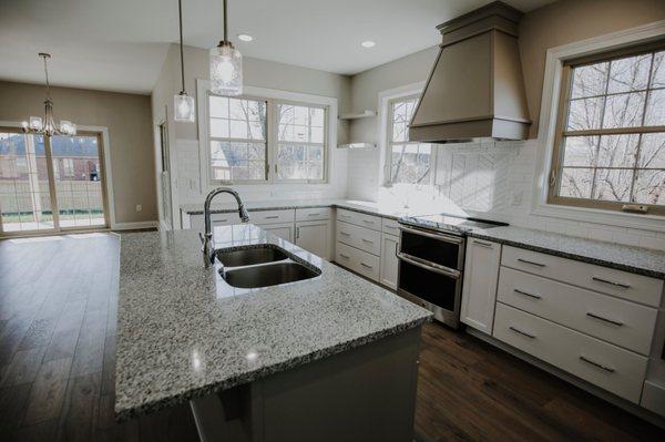 Contemporary style kitchen with no upper cabinets. Yorktowne cabinets below in sea salt. Island and range hood painted macchiato.