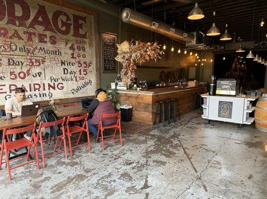 The rustic decor, warm lighting, and inviting communal seating create a welcoming space for customers to relax, work, or connect.