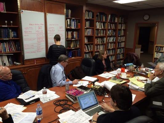 A small group strategizes the still under- construction Thomas Center For Senior Leadership.