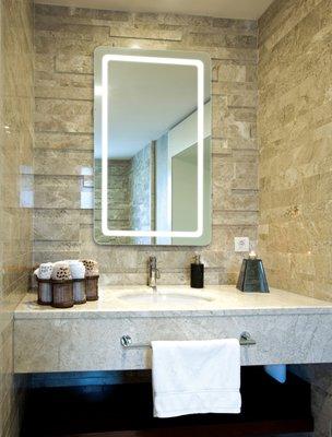 A bathroom with a lighted mirror not only meets the practical requirements of grooming but also enhances the overall  aesthetics.