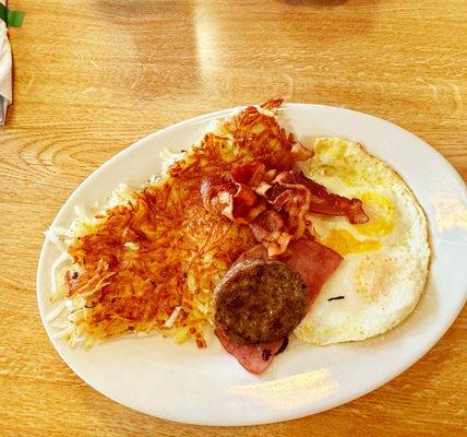 Sampler platter and he choose  sausage, eggs and hash-browns, and out of the picture were two fluffy pancakes.