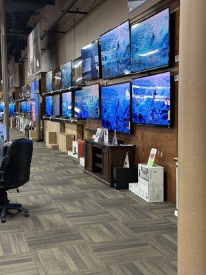 TV demo wall showcasing dozens of different TVs and their quality