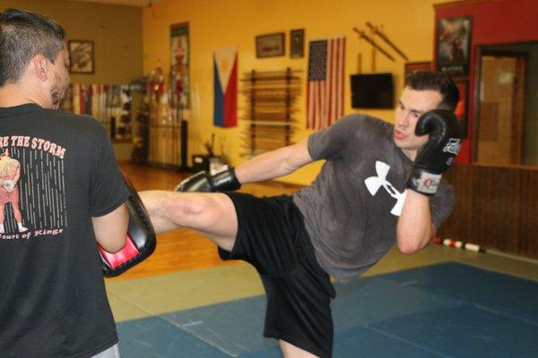 A Certified Muay Thai Instructor Lee Taningco holds pad training for Nick