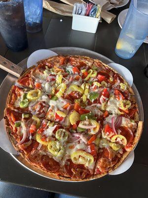 Pizza with pepperoni, green peppers, red peppers, banana peppers