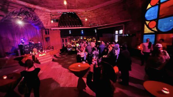 Interior of bar with DJ and giant stained glass windows