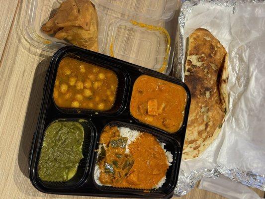 Basmati rice, butter chicken, chickpeas, spinach with cottage cheese cubes, spicy eggplant, and garlic naan