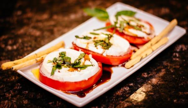 Imported Buffalo Mozzarella is used on organic tomatoes with reduced balsalmic and fresh basil grown on site