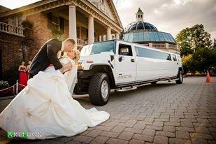 bride and groom next to limo