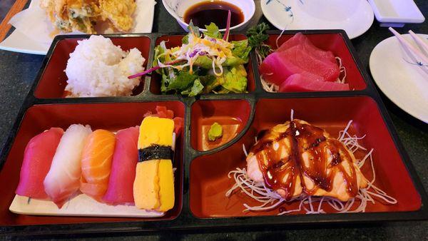 Bento box. Sashimi, assorted nigiri sushi, salmon, salad, rice, tempura, and miso soup.