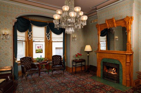 Cozy parlor with original chandelier and original fireplace